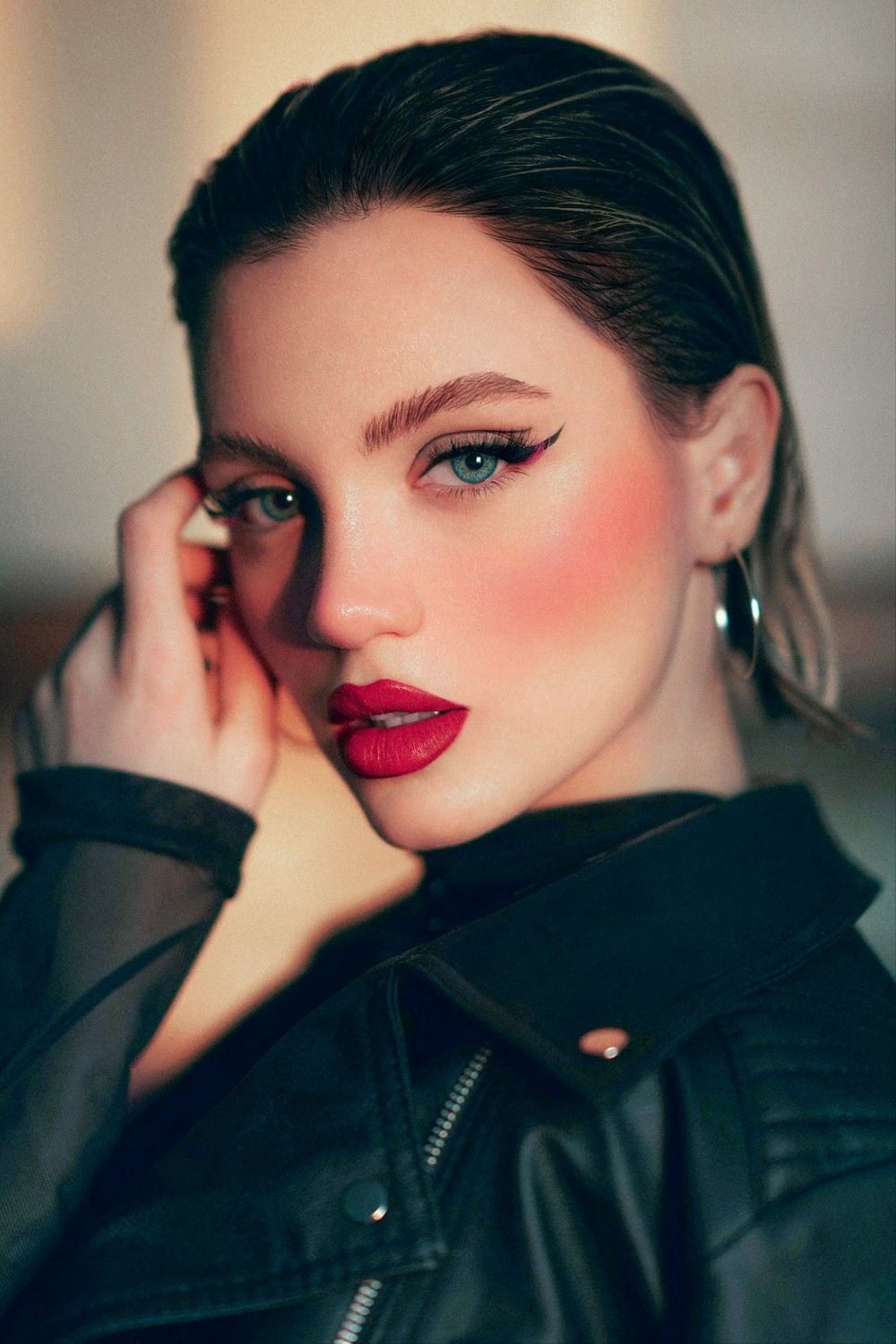 A close portrait shaped by warm light, deep shadow, and careful colour retouching.