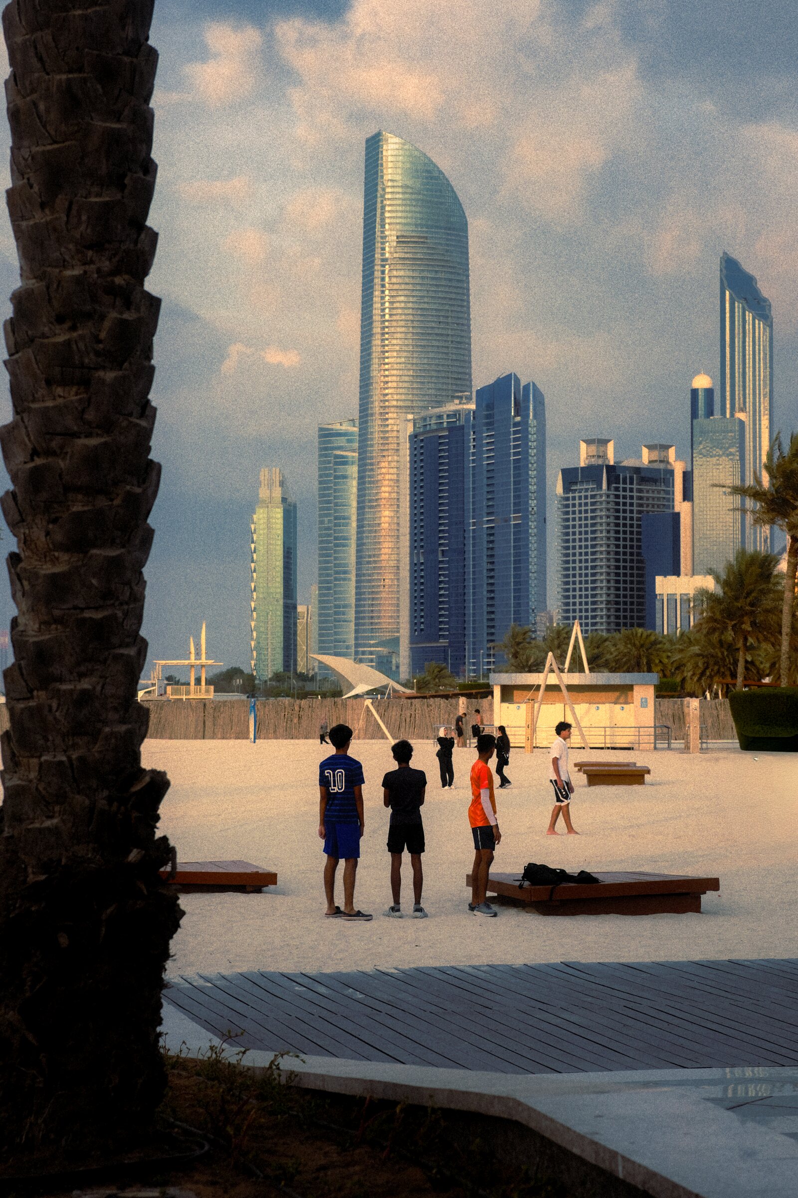 Figures along the Corniche with the Abu Dhabi skyline behind
