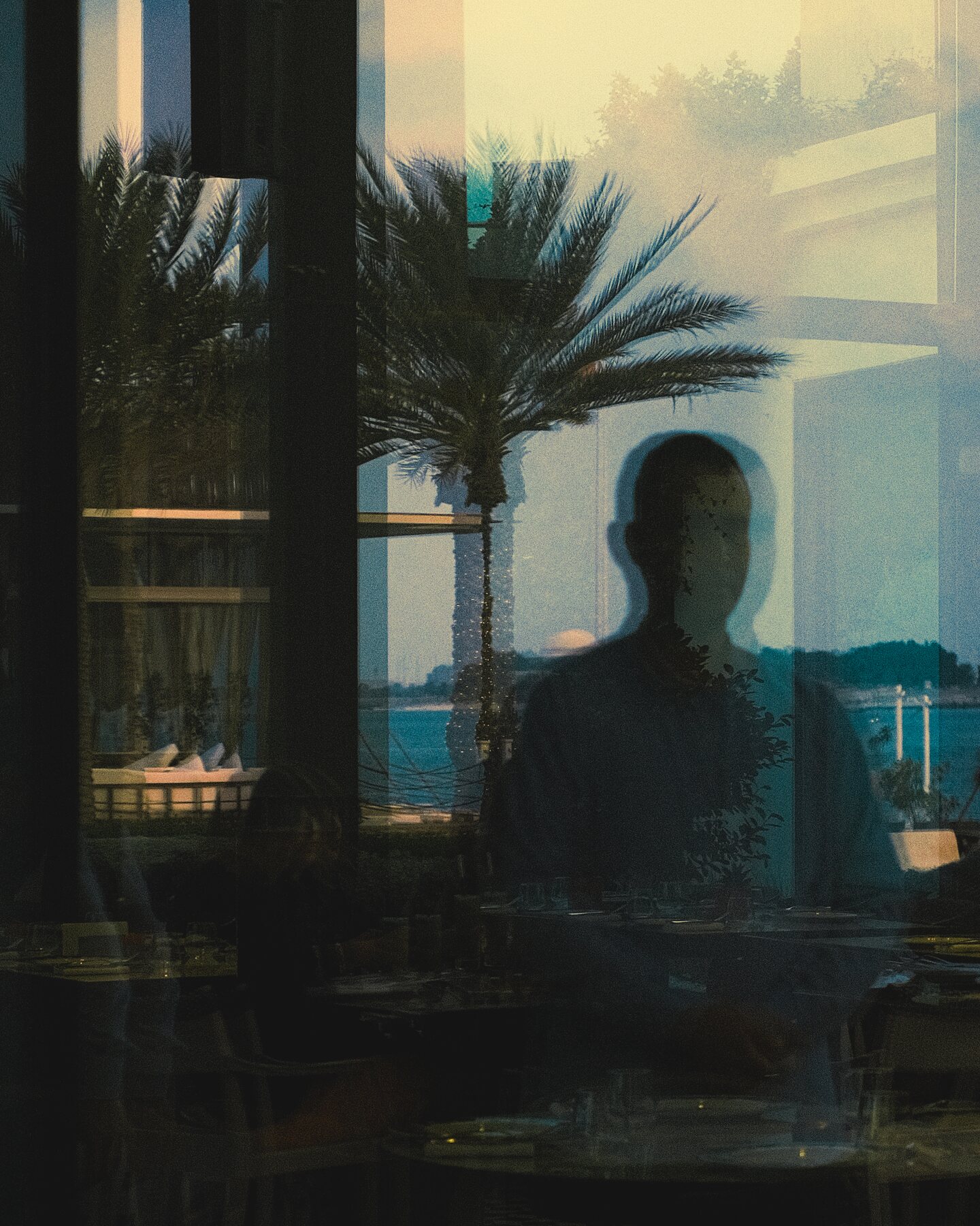 Double exposure portrait blurred against the Abu Dhabi skyline